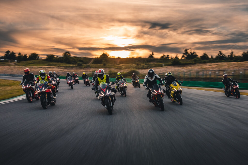 A group of motorbikes driving along the Brno autodrome at sunset