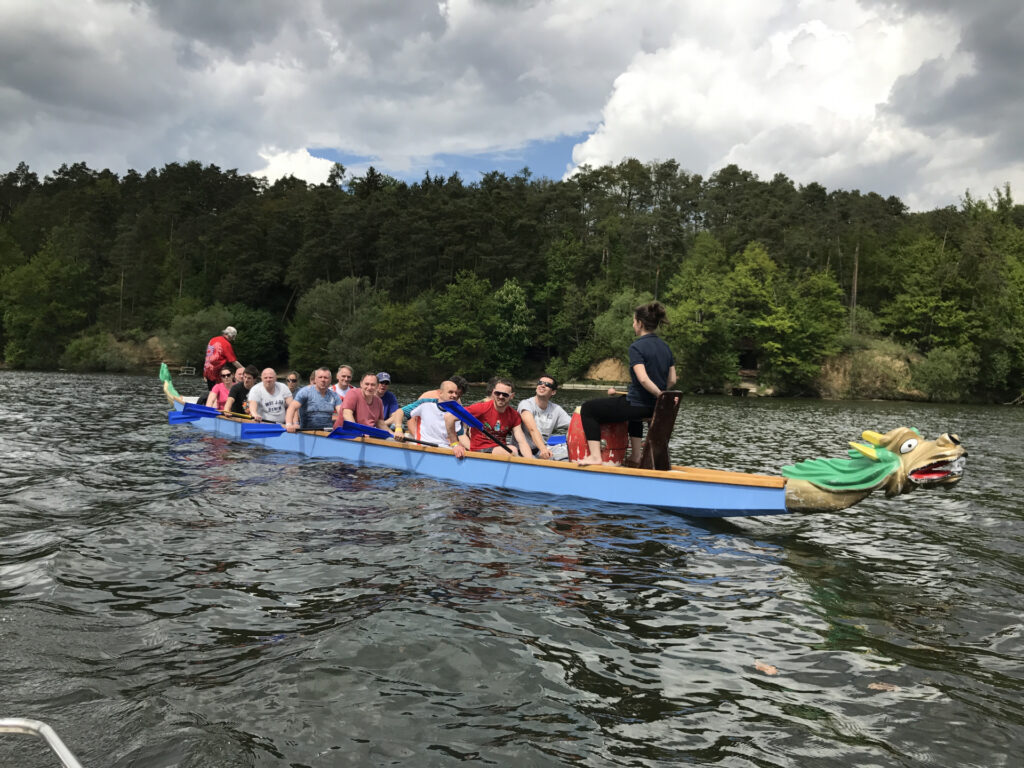 Group of people on water in blue dragon boat