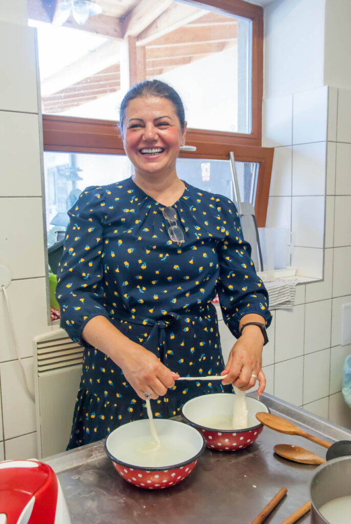 Smiling lady making cheese by hand