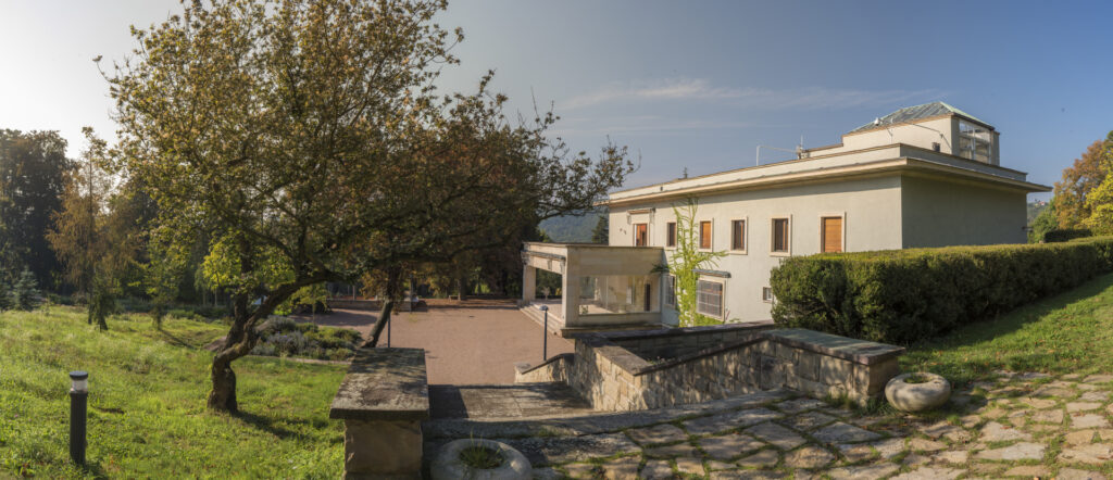 View of Villa Stiassni under blue sky with garden