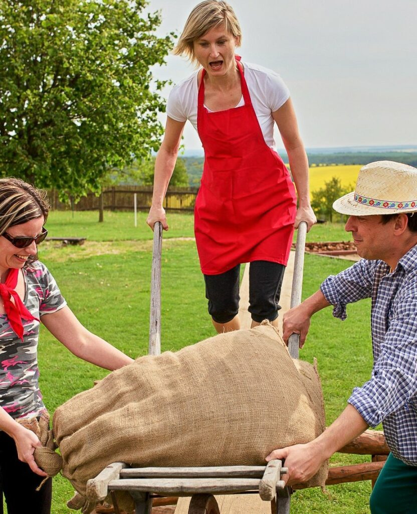 team building activity where a lady pushes a wheelbarrow with a bag of flour at the Bukovany mill