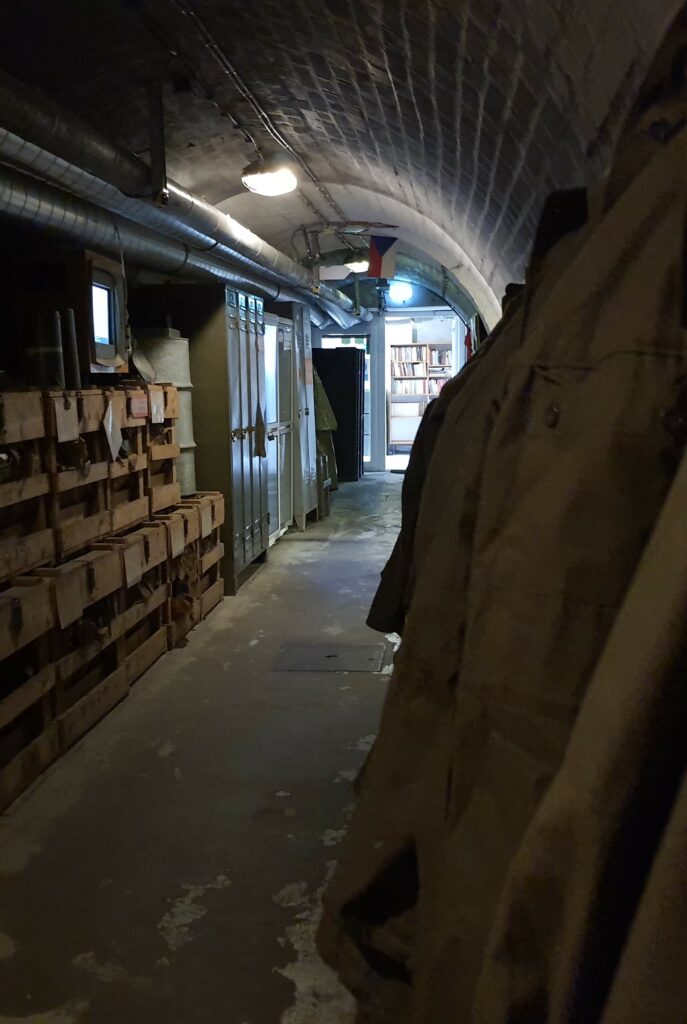 Bunker 10-z area with hanging coats on one side and stacked crates on the other