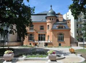 Front view of Villa Löw Beer, with fountain in foreground