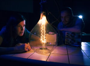 Vida science center after dark with a large light bulb